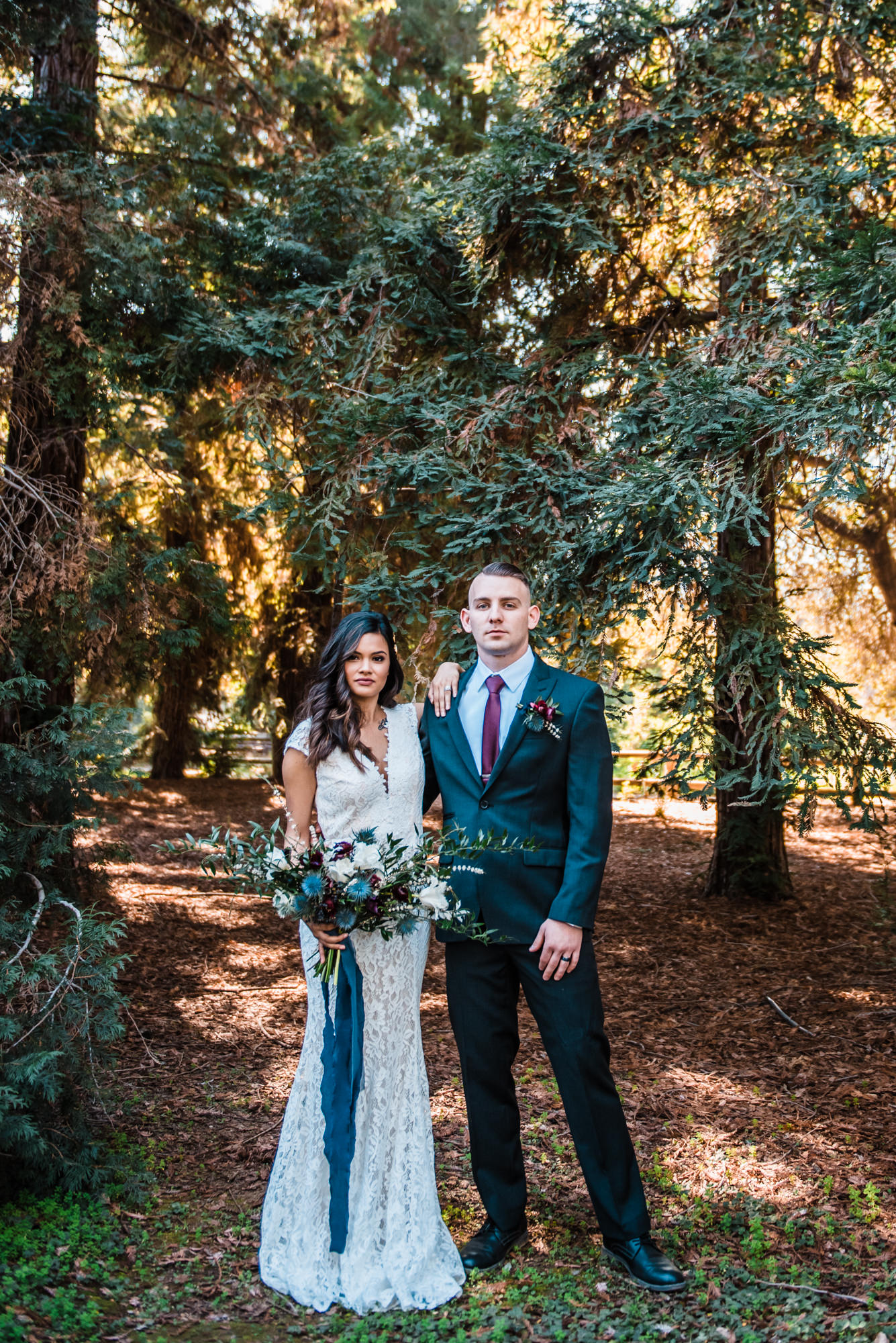 bride and groom stand where the forest begins during their outdoor elopement