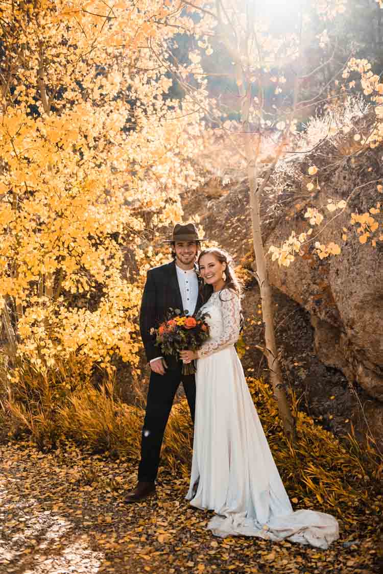 bride and groom being photographed during forest elopement in colorado