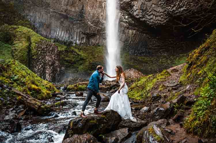 A bride and groom with a waterfall in the background