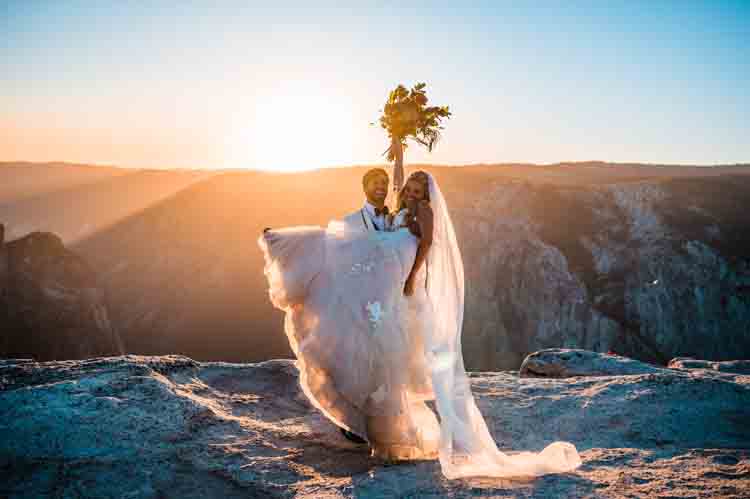 A groom carrying a bride on the top of a mountain