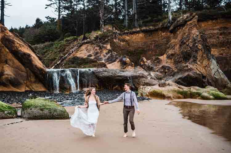 A couple holding hands with a small waterfall in the background