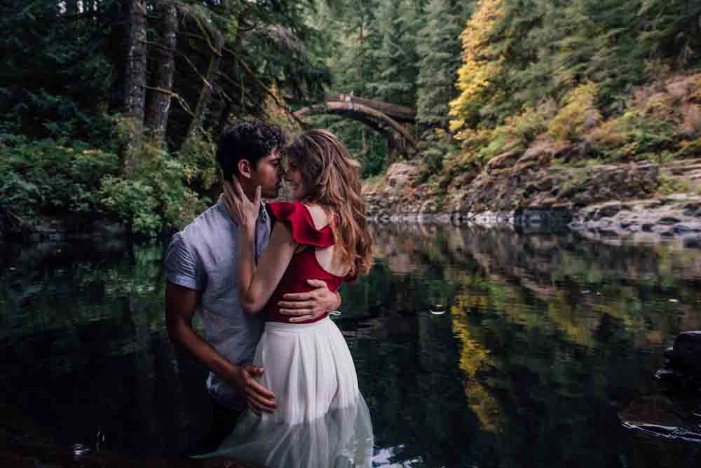 A couple inside a river in a forest valley