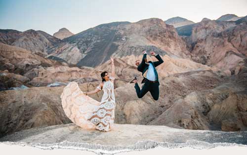 Bride and groom jumping in excitement during a desert elopement