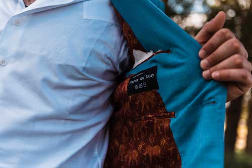 A groom showing the pattern on the inside of his jacket during an elopement