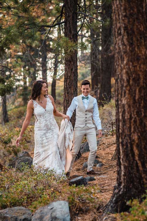 A bride and groom walking through the woods during an elopement
