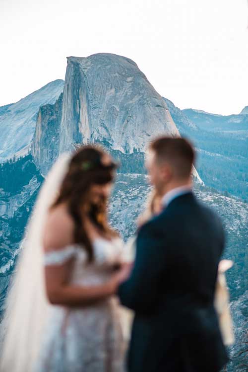 A bride and groom being married during an elopement with yosemite in the background