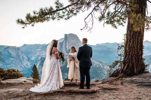 A bride and groom getting married on a cliff overlooking yosemite during an elopement