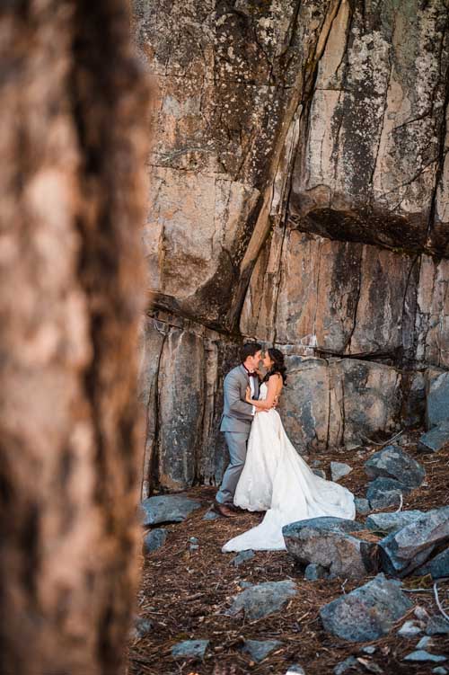 A couple kissing next to a rocky cliff during a lake tahoe elopement