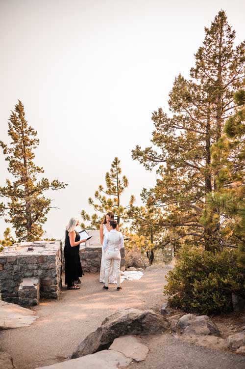 A couple being married during an elopement on top of a cliff in lake tahoe